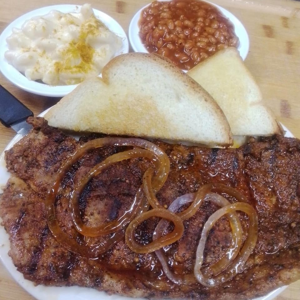 Southern BBQ Hilltop's BBQ pork steak with onions, mac and cheese, baked beans, and toast.