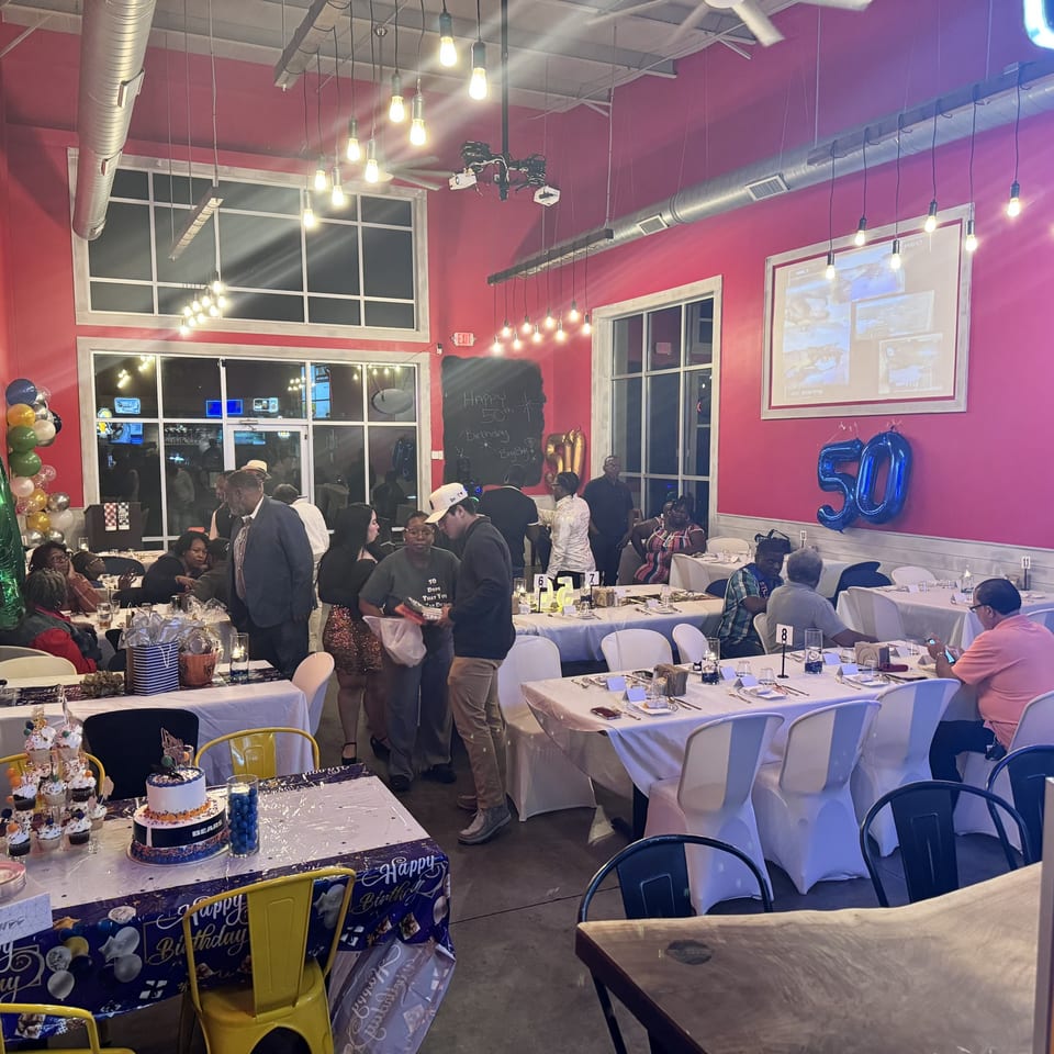 A lively birthday party at Southern BBQ Hilltop, with guests mingling and seated at decorated tables.